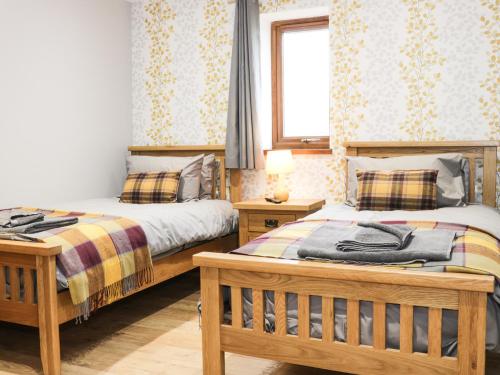 two beds sitting next to each other in a bedroom at Gardener's Lodge in Nantwich