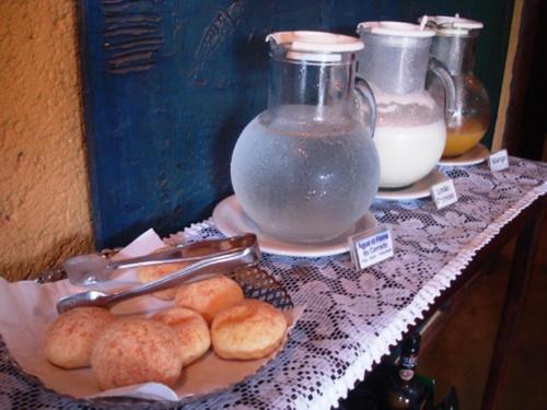a table with a plate of biscuits and a jar of milk at Pousada Bambu Brasil in Sao Jorge