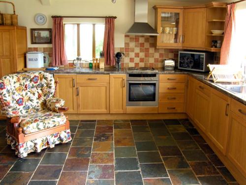 eine Küche mit einem Sofa und einem Stuhl in der Küche in der Unterkunft The Coach House in Shrewsbury
