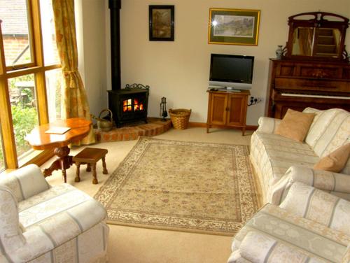 a living room with two couches and a fireplace at The Coach House in Shrewsbury