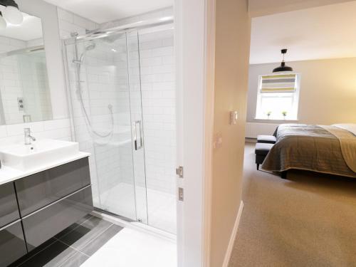 a bathroom with a shower and a sink and a bed at The Old Post Office in Garstang