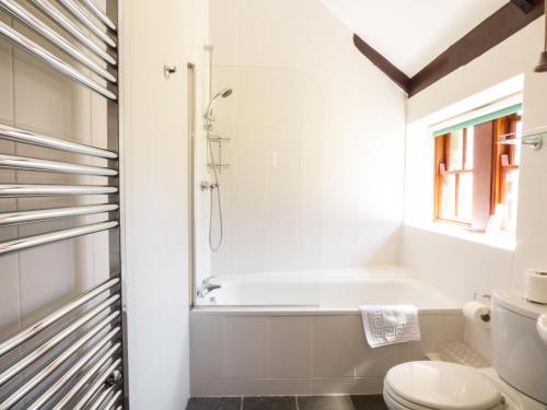 a bathroom with a tub and a toilet at Parlour Cottage in Saint Erth