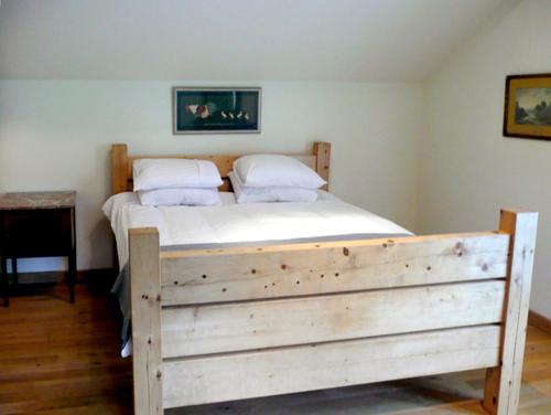 a wooden bed with two pillows on it in a bedroom at Glan Clwyd Isa - The Coach House in Denbigh