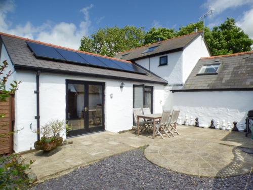 a patio with a table and chairs and a house at The Old Granary in Haverfordwest