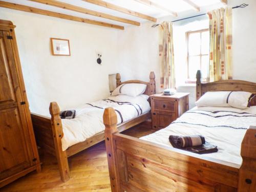 two beds in a room with wooden floors at The Old Granary in Haverfordwest