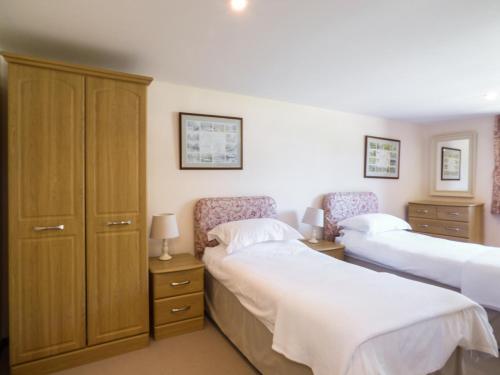 ein Schlafzimmer mit zwei Betten und einem Schrank in der Unterkunft Parlour Cottage in Saint Erth