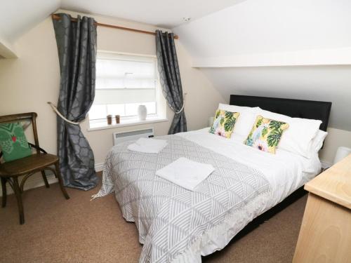 a bedroom with a bed and a window at October Cottage in Ripon