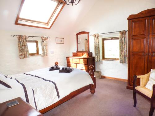 a bedroom with a bed and a dresser and a mirror at The Old Granary in Haverfordwest
