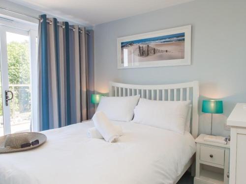 a bedroom with a white bed and a window at Bayview in Brixham