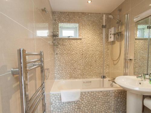 a bathroom with a bath tub and a sink at Bayview in Brixham