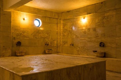 a room with two toilets and a stone wall at Halıcı Hotel Resort & SPA in Pamukkale