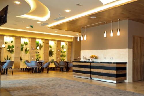 a restaurant with tables and chairs in a lobby at Mercure Tetovo in Tetovo