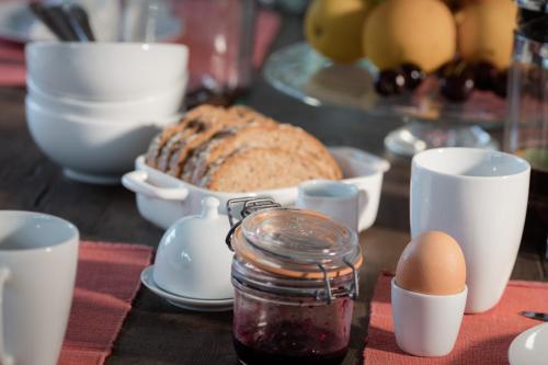 a table with bread and eggs and a jar of jam at B&B La Gotale in Manhay