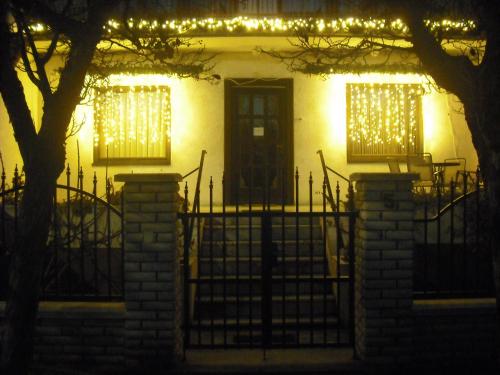 a house with a gate in front of it at night at Szilvia Panzió Gyomaendrőd in Gyomaendrőd