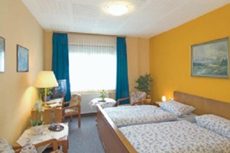a hotel room with two beds and a window at Landgasthaus Hoffmeister in Hehlen
