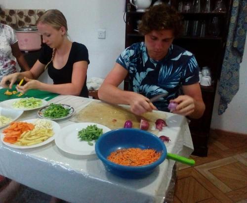 a man and a woman preparing food on a table at Ella Jayamali Holiday Pavilion in Ella