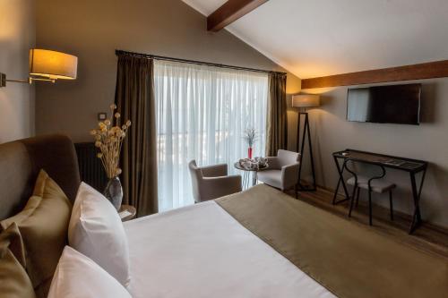 a hotel room with a bed and a desk and a television at Marin Otel & Restaurant in Samsun