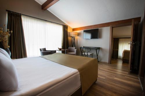 a hotel room with a bed and a living room at Marin Otel & Restaurant in Samsun