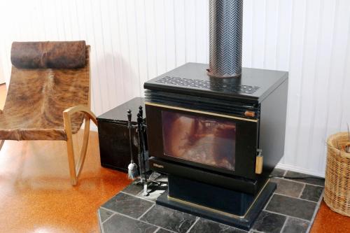 a stove sitting on top of a floor with a chair at Valley View Luxury Retreat in Vacy