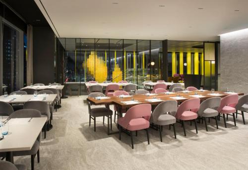 a dining room with tables and pink chairs at L7 GANGNAM by LOTTE in Seoul