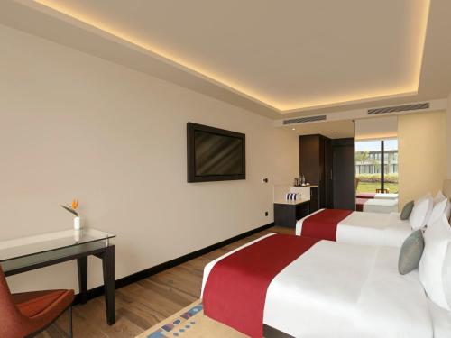 a hotel room with two beds and a desk at Tiger Palace By Soaltee in Bhairāhawā