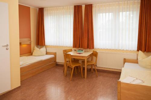 a room with a table and a bed and a table and chairs at DJH Jugendherberge Dresden - Jugendgästehaus in Dresden