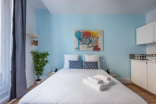 une chambre avec un grand lit blanc avec des serviettes dessus dans l'établissement WS Hôtel de Ville - Musée Pompidou, à Paris