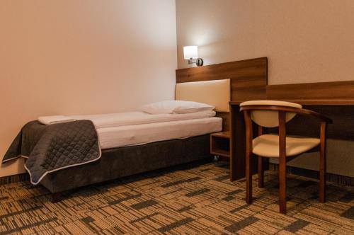 a bedroom with a bed and a desk and a chair at Centrum Promocji Leśnictwa w Mucznem in Lutowiska