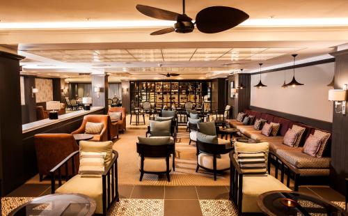 a lobby with a bar with chairs and tables at Avani Gaborone Resort & Casino in Gaborone