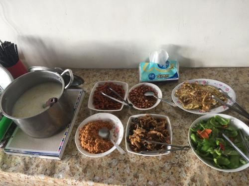 a counter with bowls of food and a pot of food at Siangting B&B in Fenqihu