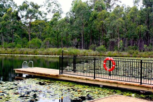 a dock with a red life preserver next to a lake at Valley View Luxury Retreat in Vacy