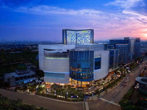 a large building in a city at night at Holiday Inn Express Jakarta Pluit Citygate by IHG in Jakarta