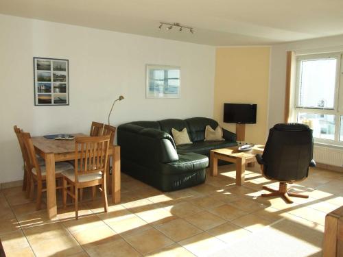 una sala de estar con un sofá y una mesa en Ostseewohnung Nr 14 Villa Mare, en Glücksburg