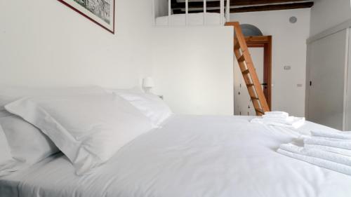 ミラノにあるItalianway-Pastrengo 11 Flatの白い枕とはしご付きの白いベッド