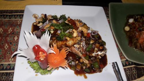 a white plate with food on a table at Lanka Beach Boutique Bungalows & Grand Villa in Tangalle