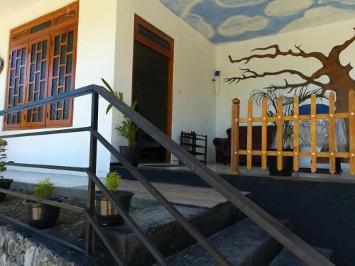 a house with a tree mural on the wall at White Arcadia cottage in Ella