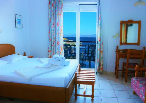 a bedroom with a bed and a view of the ocean at Akti Hotel in Limenas