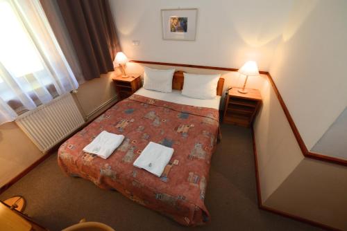 a hotel room with a bed and two lamps at Bakony Hotel in Bakonybél