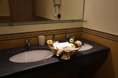 a bathroom sink with a basket of flowers on it at Villa Nina in La Spezia