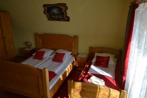 two beds with red pillows in a bedroom at Durda in Poronin