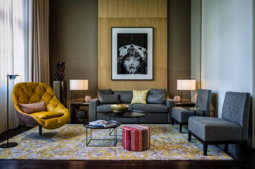 a living room with a couch and a chair at SO/ Berlin Das Stue in Berlin