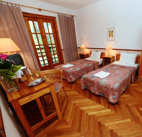 a hotel room with two beds and a table at Bakony Hotel in Bakonybél