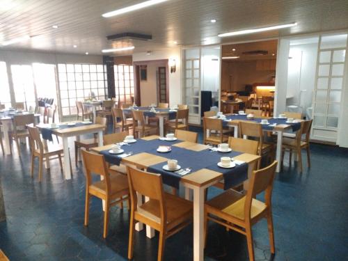 una sala da pranzo con tavoli e sedie in legno di Hotel Marqués de Santillana a Torrelavega