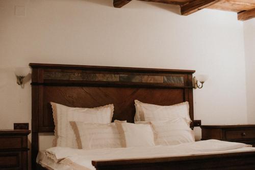 a bed with a wooden headboard and white pillows at La Saca 42 in Saca