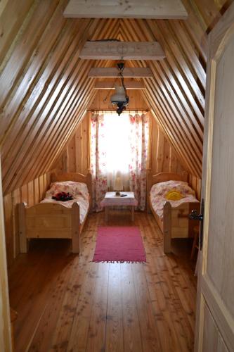 a attic room with two beds and a window at Durda in Poronin
