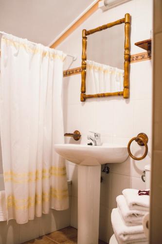 a bathroom with a sink and a shower curtain at Posada Marina in Suances