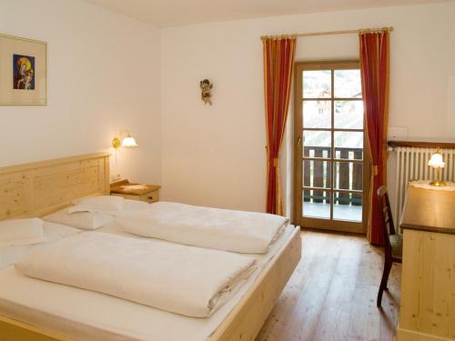 a bedroom with two beds and a large window at Plonerhof in Lagundo