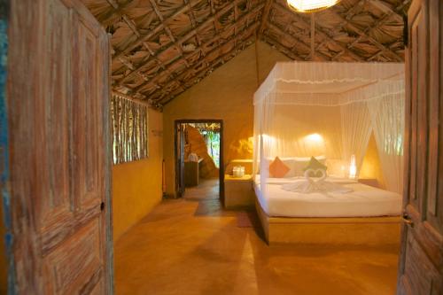 a bedroom with a bed with a canopy in a room at Bar Reef Resort in Kalpitiya