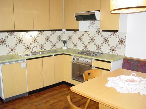 a kitchen with a table and a sink and a stove at Plonerhof in Lagundo