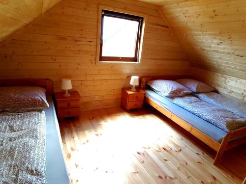 Un dormitorio con dos camas en una cabaña de madera. en Ferienhäuser Eurobaltyk, en Rewal